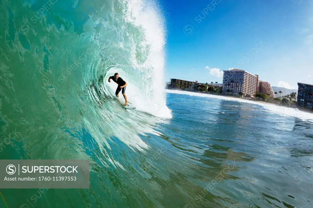 Professional surfer Dusty Payne gets barreled on beautiful blue wave; Maui, Hawaii, United States of America