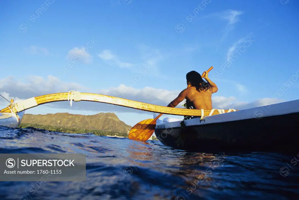 Hawaii, Oahu, Topless woman paddling outrigger canoe, Diamond Head in  distance, view from behind. NO MODEL RELEASE - SuperStock