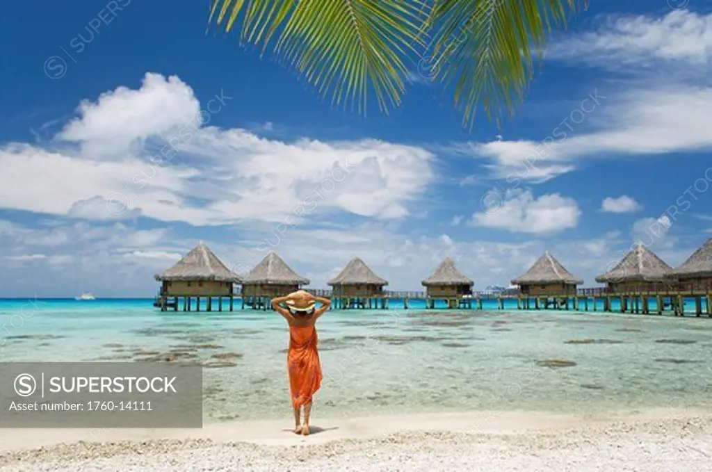 French Polynesia, Tuamotu Islands, Rangiroa Atoll, Woman on beach near luxury resort.