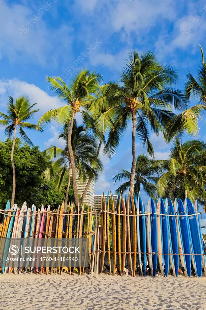 A rack of colourful surfboards lined up on Waikiki Beach; Honolulu, Oahu, Hawaii, United States of America