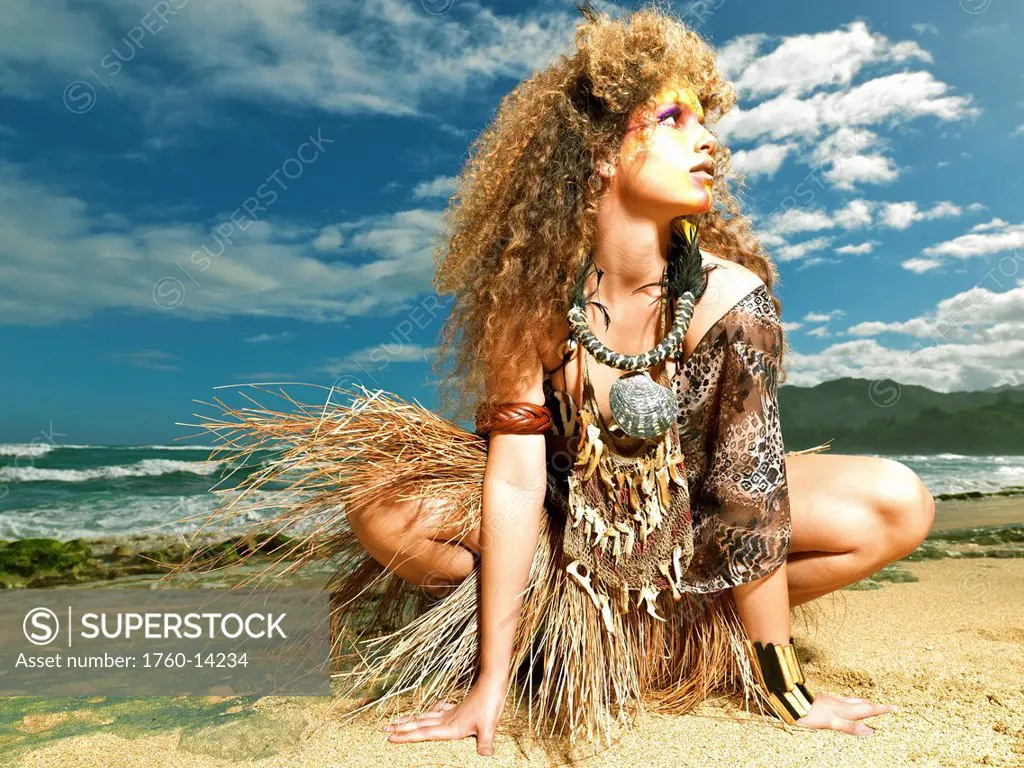 Hawaii, Kauai, Haena, Model poses with Polynesian tribal fashions.