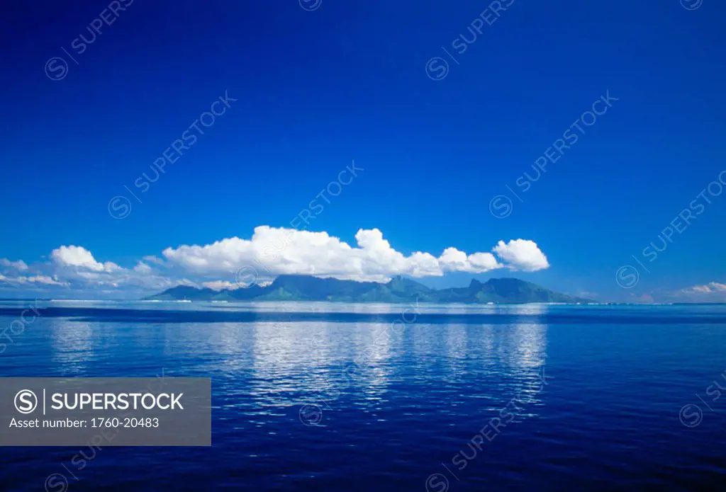 French Polynesia, Tahiti, Cumulus clouds over a calm ocean.