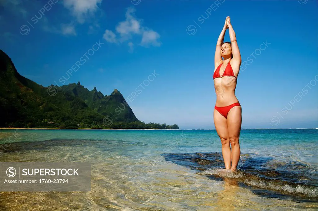 Hawaii, Kauai, North Shore, Tunnels beach, Woman doing yoga.