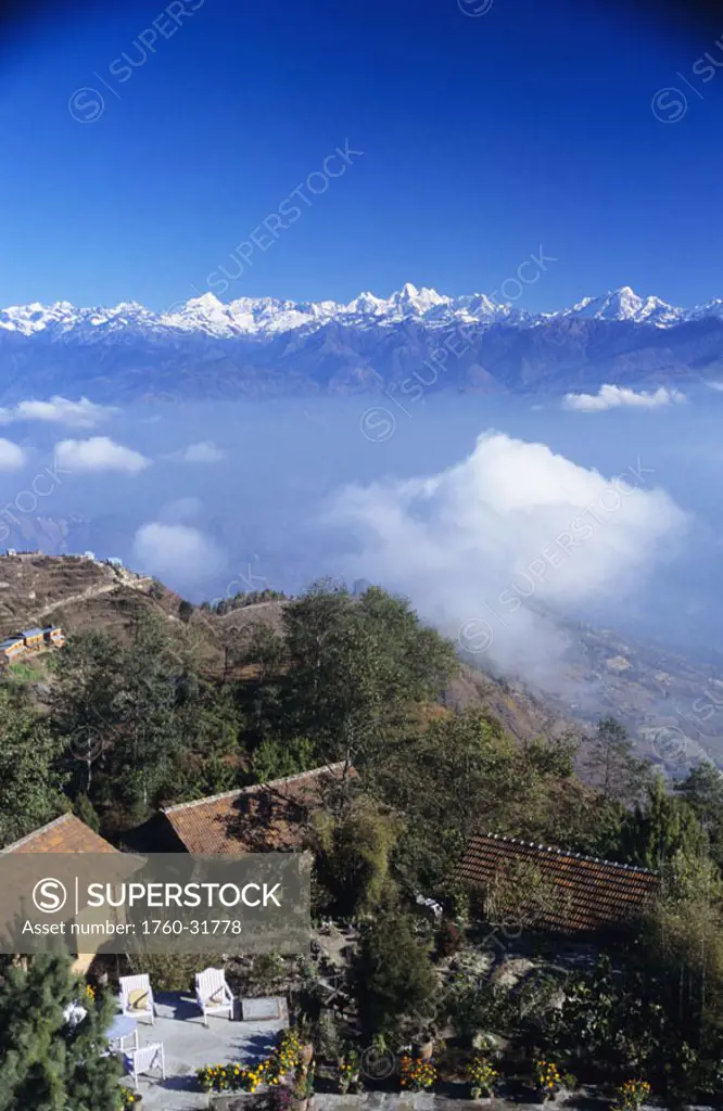 Nepal, Nagarkot, Fort Hotel, overview of hillside and clouds, Himalayan mountains in background.