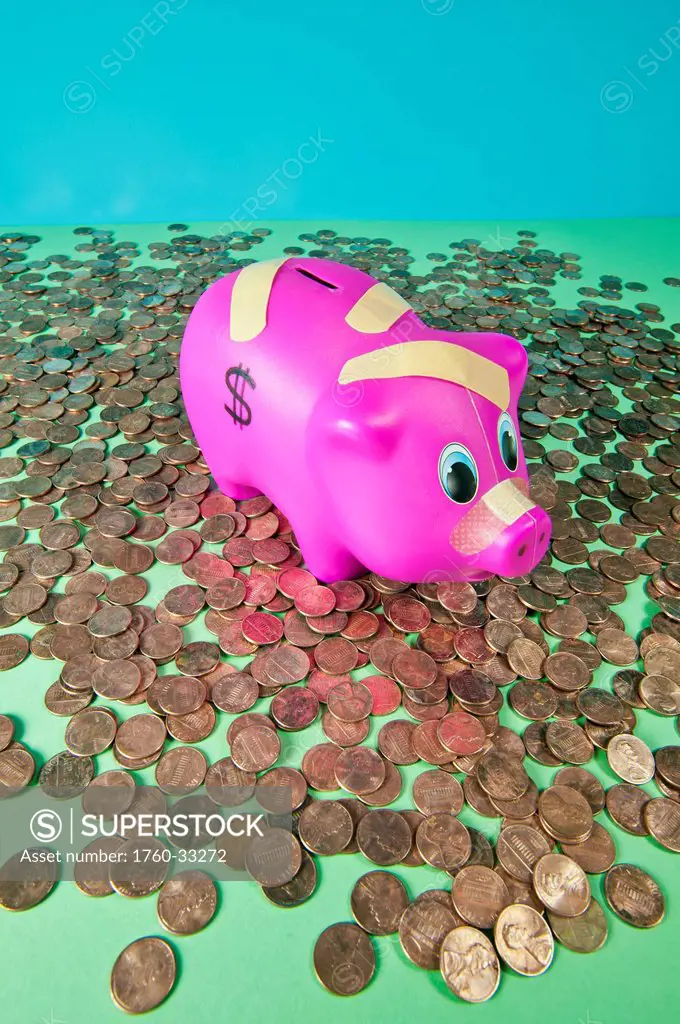 Studio Shot Of A Childs Piggy Bank Surrounded By Pennies And Covered In Bandaids.