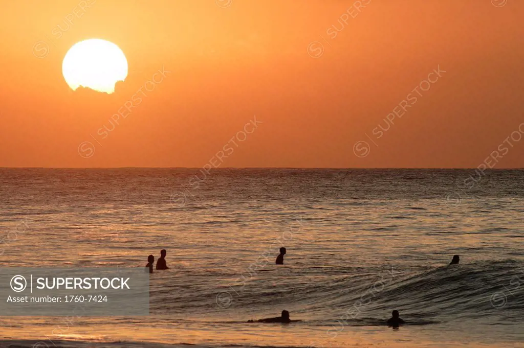 Hawaii, Oahu, North Shore, surfers at sunset