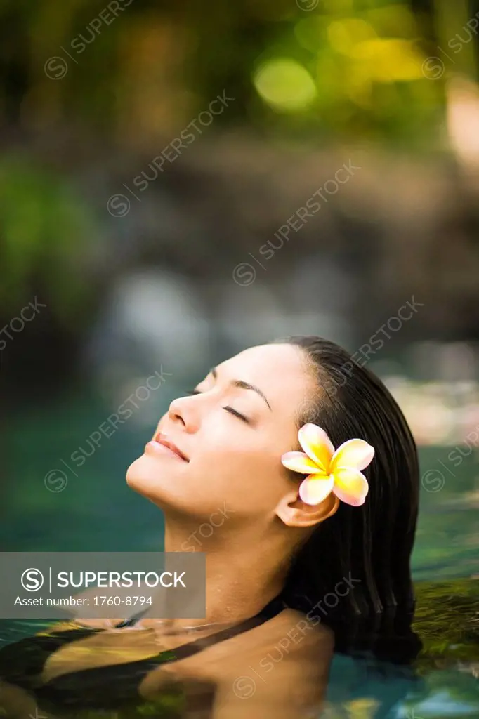 Hawaii, Oahu, Closeup of young woman´s face relaxing in tropical pool.