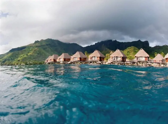 French Polynesia, Moorea Lagoon Resort, Bungalows over beautiful turquoise ocean.