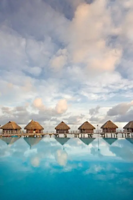 French Polynesia, Pearl Resort, Bungalows over beautiful turquoise ocean.