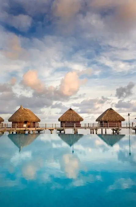 French Polynesia, Pearl Resort, Bungalows over beautiful turquoise ocean.