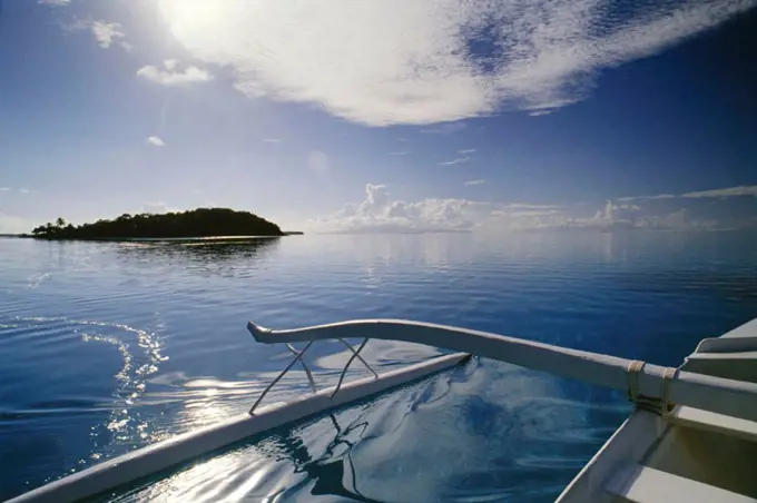 French Polynesia, Tahiti, Outrigger in coral waters of Bora Bora, Motu in background