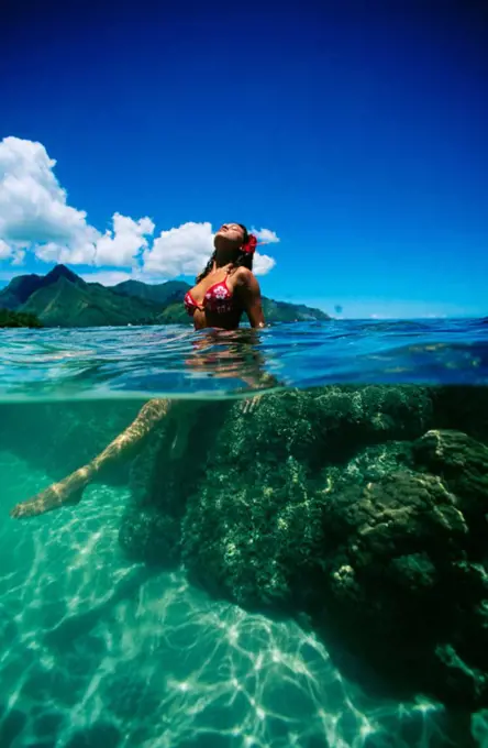 French Polynesia, Tahiti, Beautiful local woman in ocean, split view