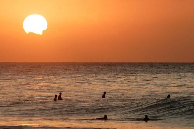 Hawaii, Oahu, North Shore, surfers at sunset