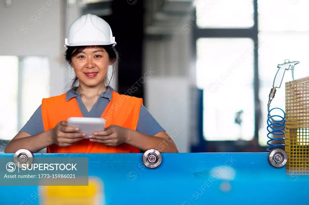 Technician using digital tablet in factory