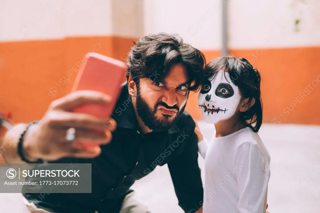 Girl and father taking Halloween selfie