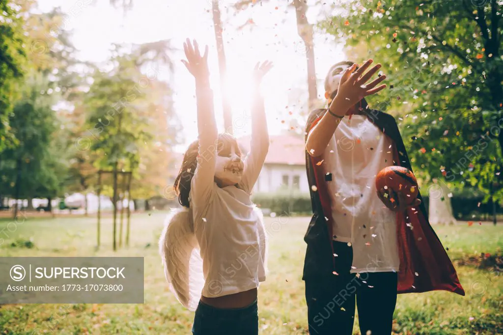 Children in Halloween costumes, throwing confetti