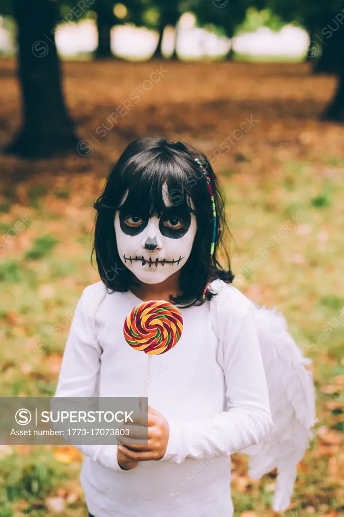 Girl in Halloween costume with lollipop