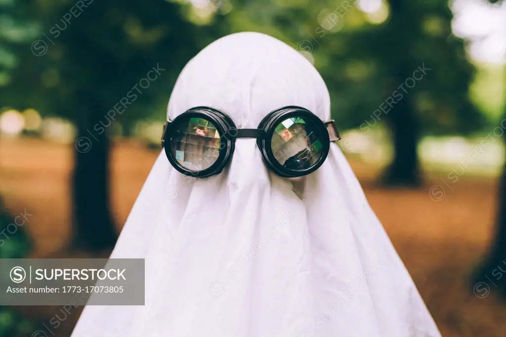 Child wearing sheet and goggles ghost Halloween costume