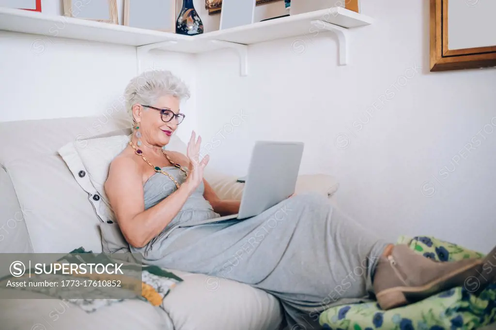 Woman on video call at home, waving