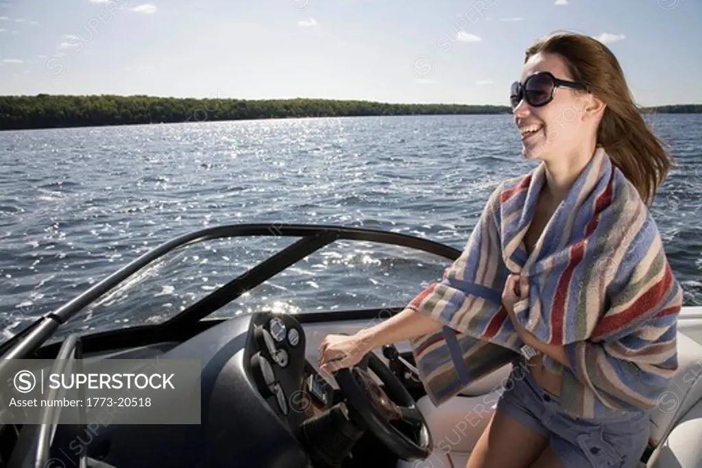 Woman driving speedboat on lake