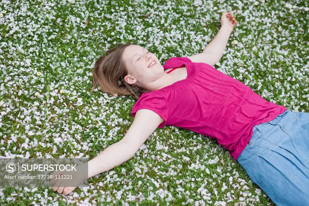 young girl lying in grass