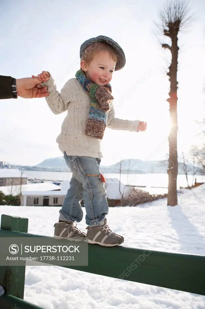 Scandinavian boy guided by fathers hand