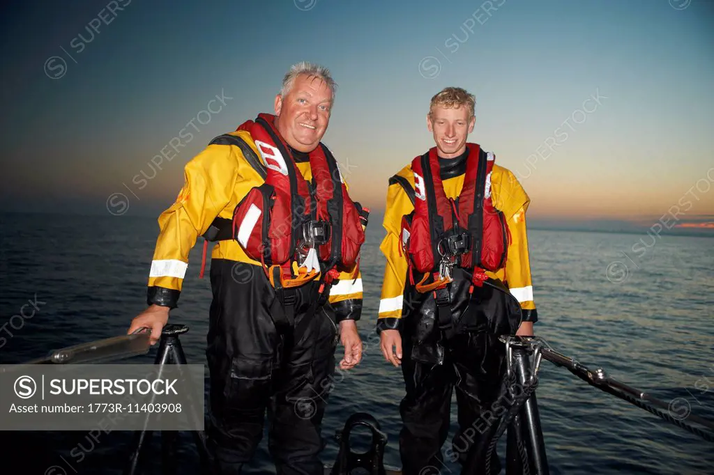 Portrait of two men crewing lifeboat at sea