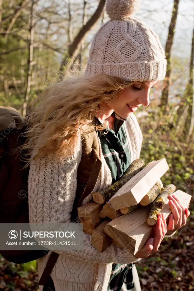 Woman collecting wood for fire by seaside