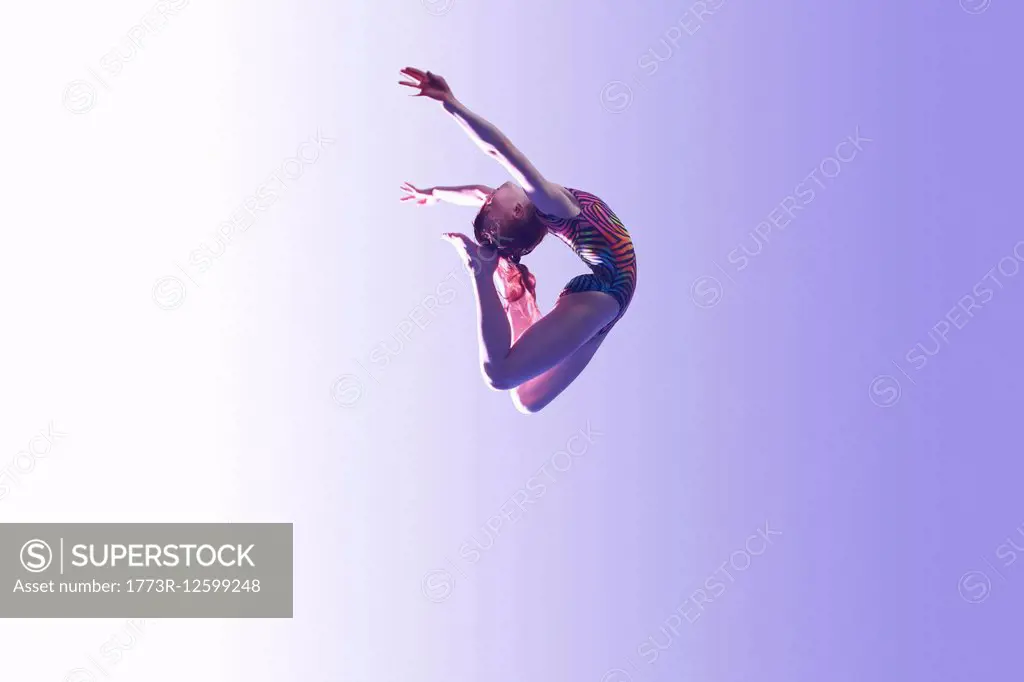 Young gymnast in mid-air leap