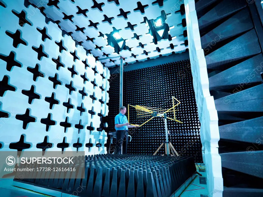 Engineer checking the bilog antenna set up for electromagnetic compatibility (EMC) radiated emissions in anechoic chamber with energy absorbers