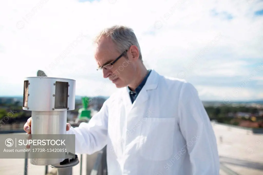 Male meteorologist monitoring meteorological equipment measurements at rooftop weather station