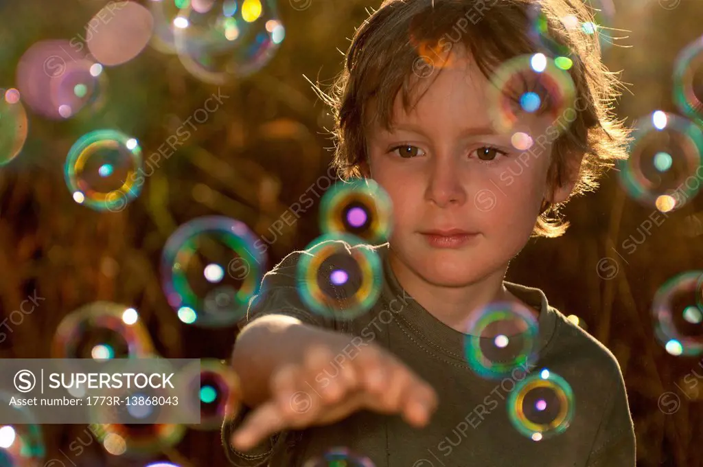 Boy playing with bubbles outdoors