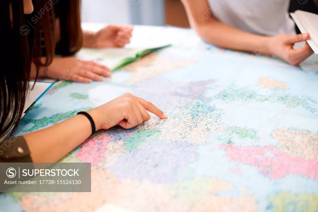 College students studying world map in classroom