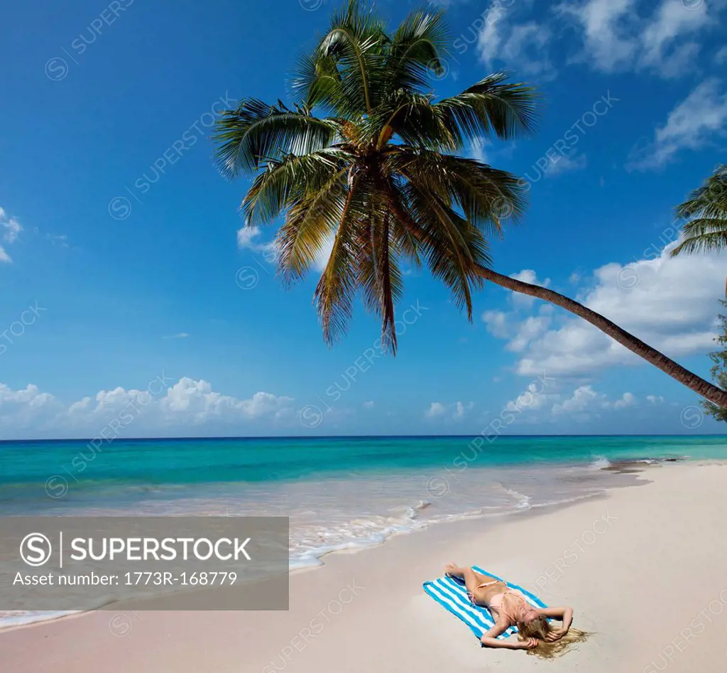 Woman laying on towel on beach