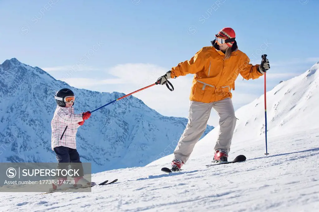 Mother pulling child on skis