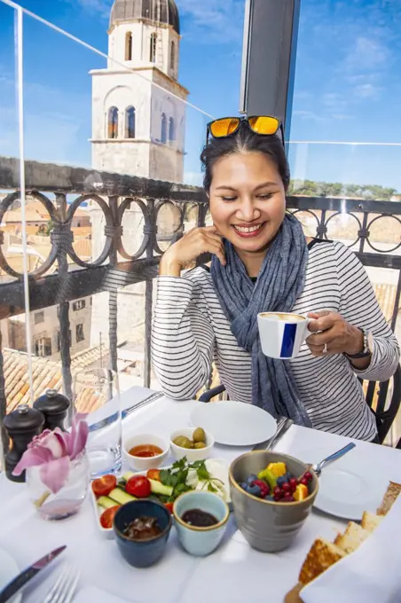 Woman drinking coffee at a rooftop restaurant in Dubrovnik, Dubrovacko-Neretvanska, Croatia