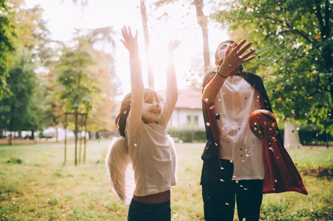 Children in Halloween costumes, throwing confetti