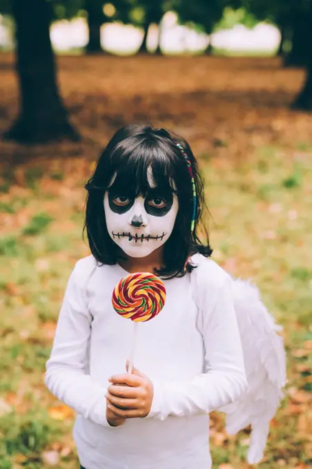 Girl in Halloween costume with lollipop