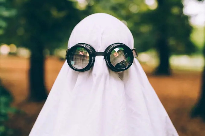 Child wearing sheet and goggles ghost Halloween costume