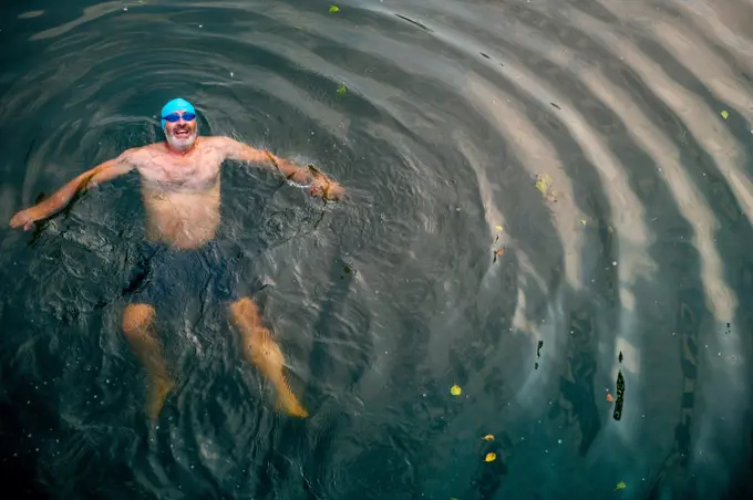 Man wild swimming in river, overhead view, River Wey, Surrey, UK