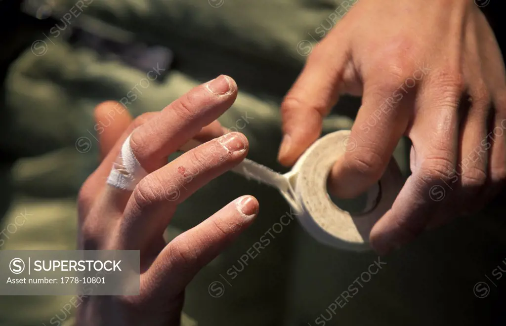 A female athlete taping her hands before rock climbing