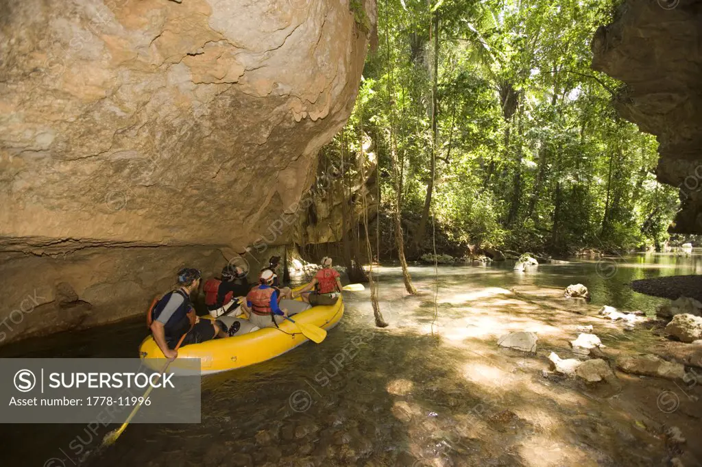 A group of adventure tourists traversing four caves by raft and kayak on Caves Branch River in Central Belize