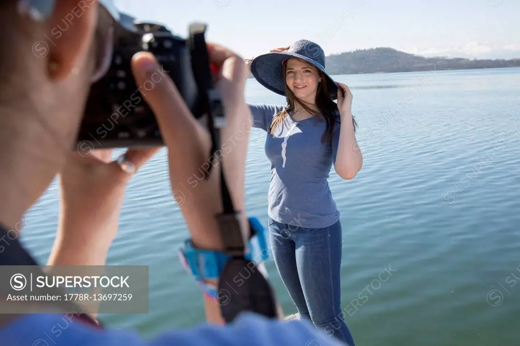 POV of teen girl taking photo of friend in hat