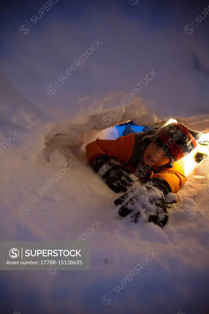 Boy digging hole in snow