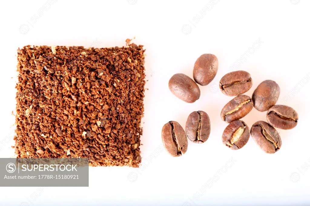 Heap of ground coffee and coffee beans on white background, Oakland, USA