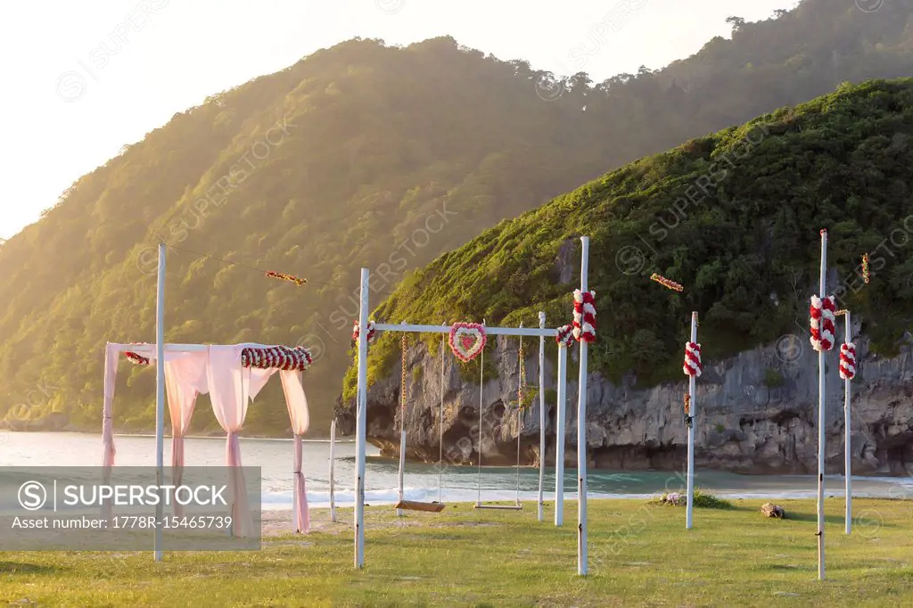 View of tent and swings on seashore with mountains in background, Banda Aceh, Sumatra, Indonesia