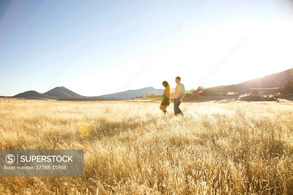 Couple in the far distance walking together in an open field.