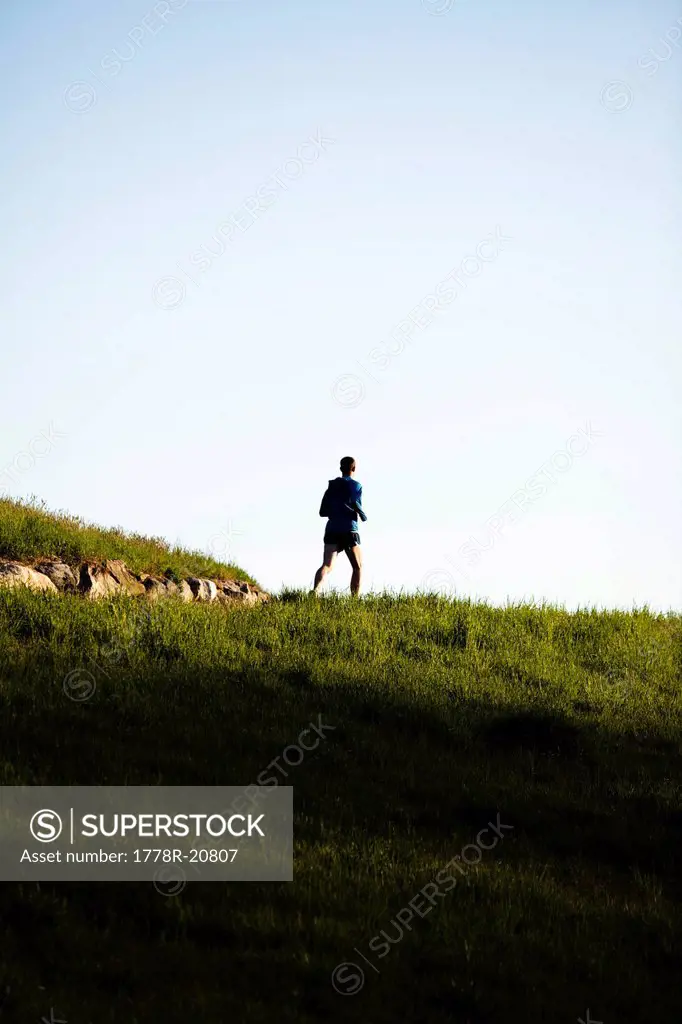 A man wearing a blue jacket runs along a trail in Rockefeller State Park in Sleepy Hollow, New York.