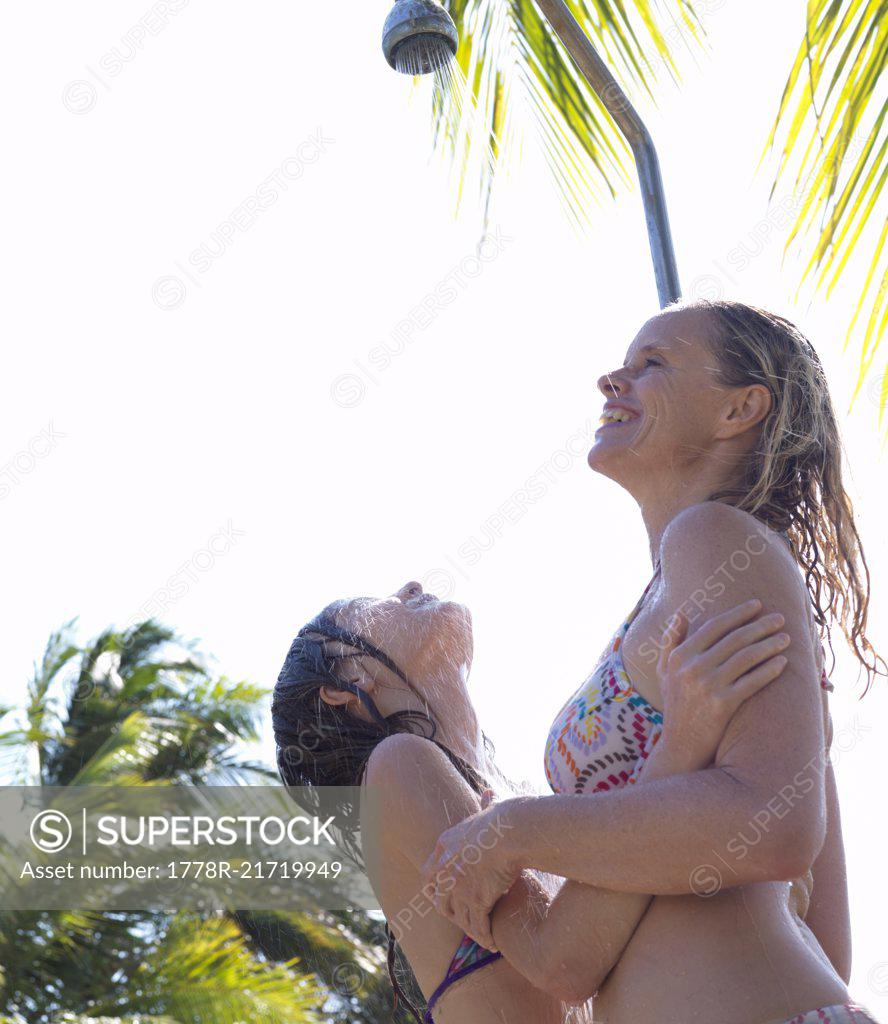 Mother and daughter share outdoor shower - SuperStock