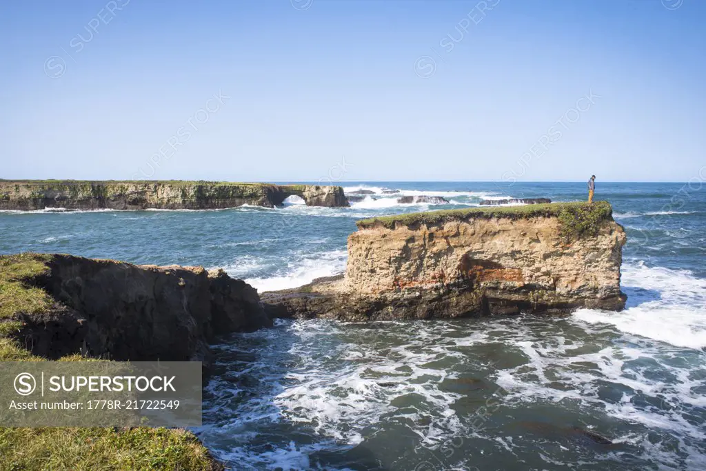 Man standing on rock and watching coastal views in Point Arena, California, USA